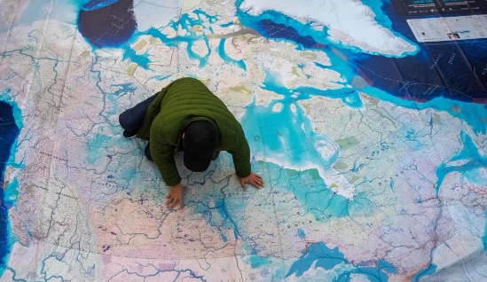 A person explores a giant map of Canada